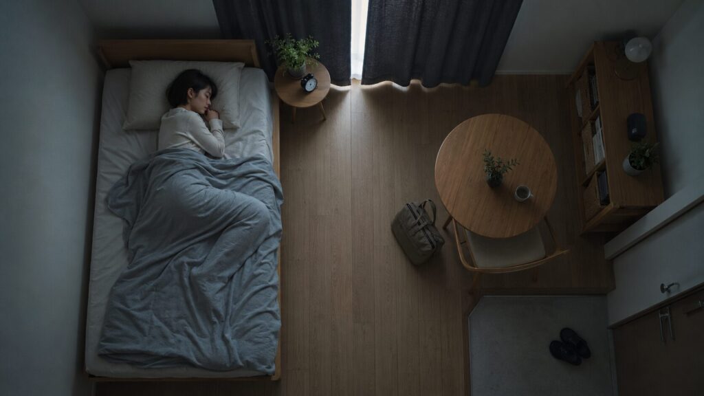 仕事を辞めた後、生活のリズムを失い、昼間の部屋で眠り続ける女性。