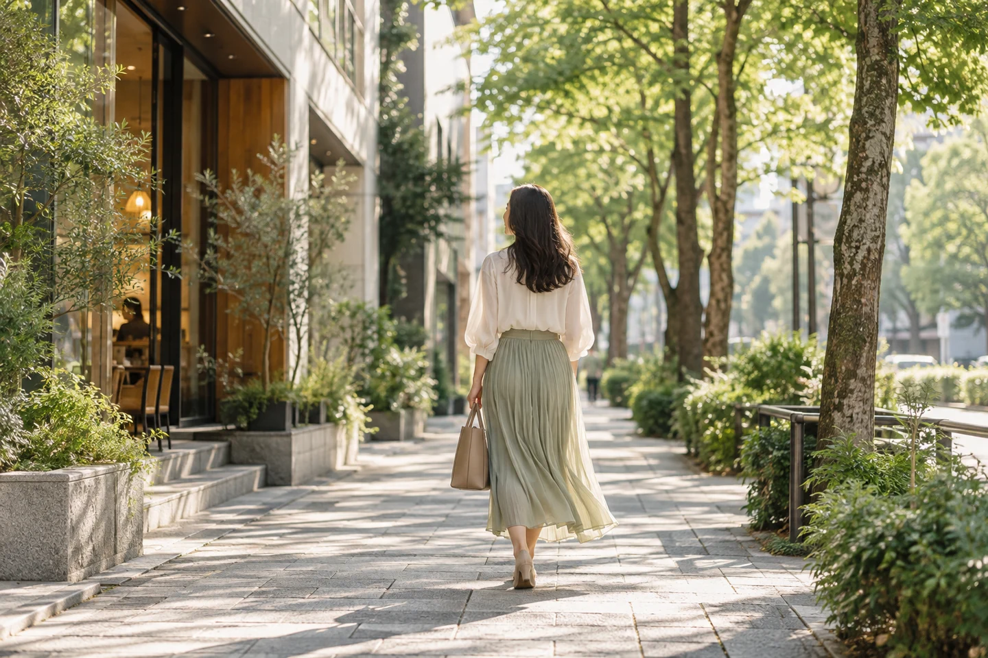 日差しのある並木道を歩く女性のイメージ